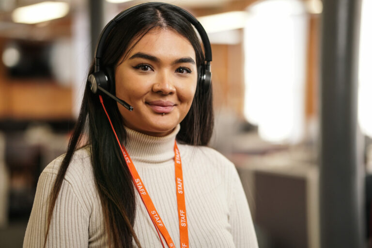 Woman Sitting At A Desk With Headphones On