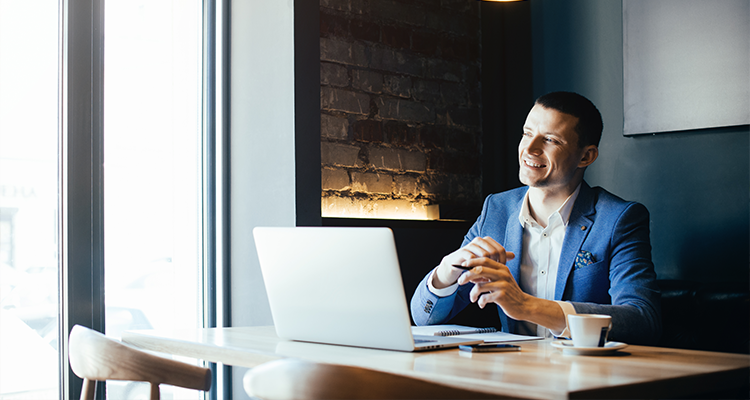 Man sitting at desk looking at laptop