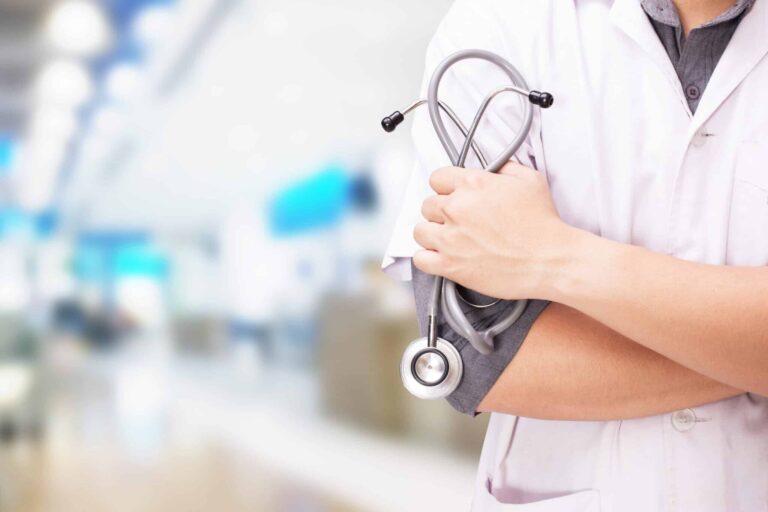 Doctor With Stethoscope Hands Hospital Background Scaled